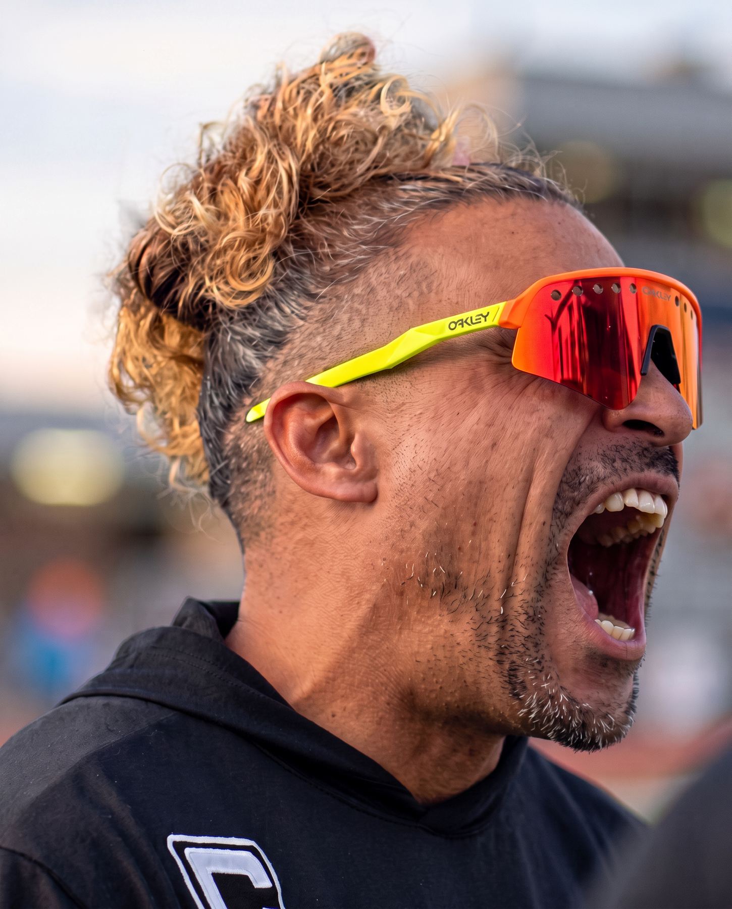 Close profile of Coach Jason coaching at full volume in performance sunglasses