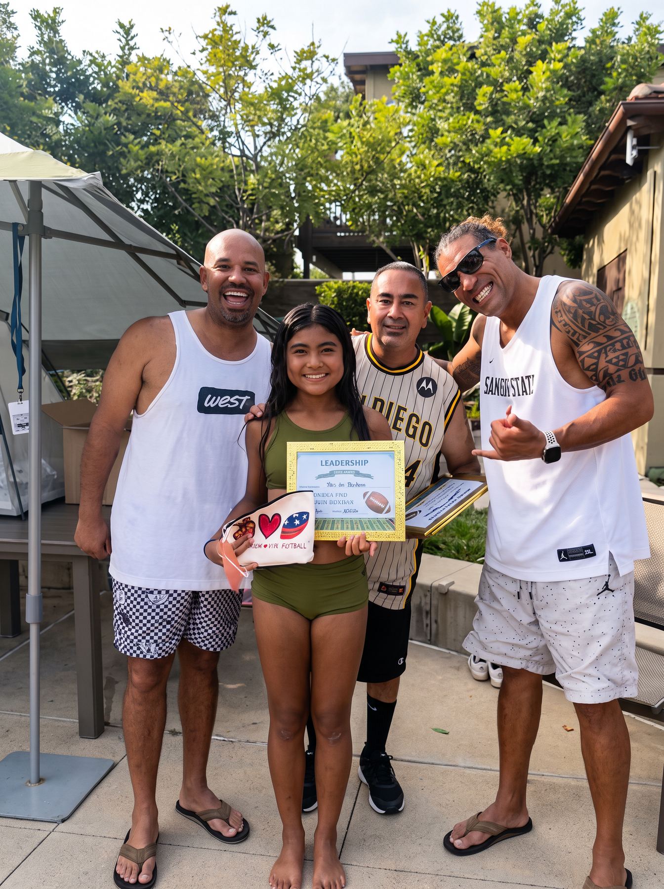A young athlete receiving a leadership award alongside her coaches